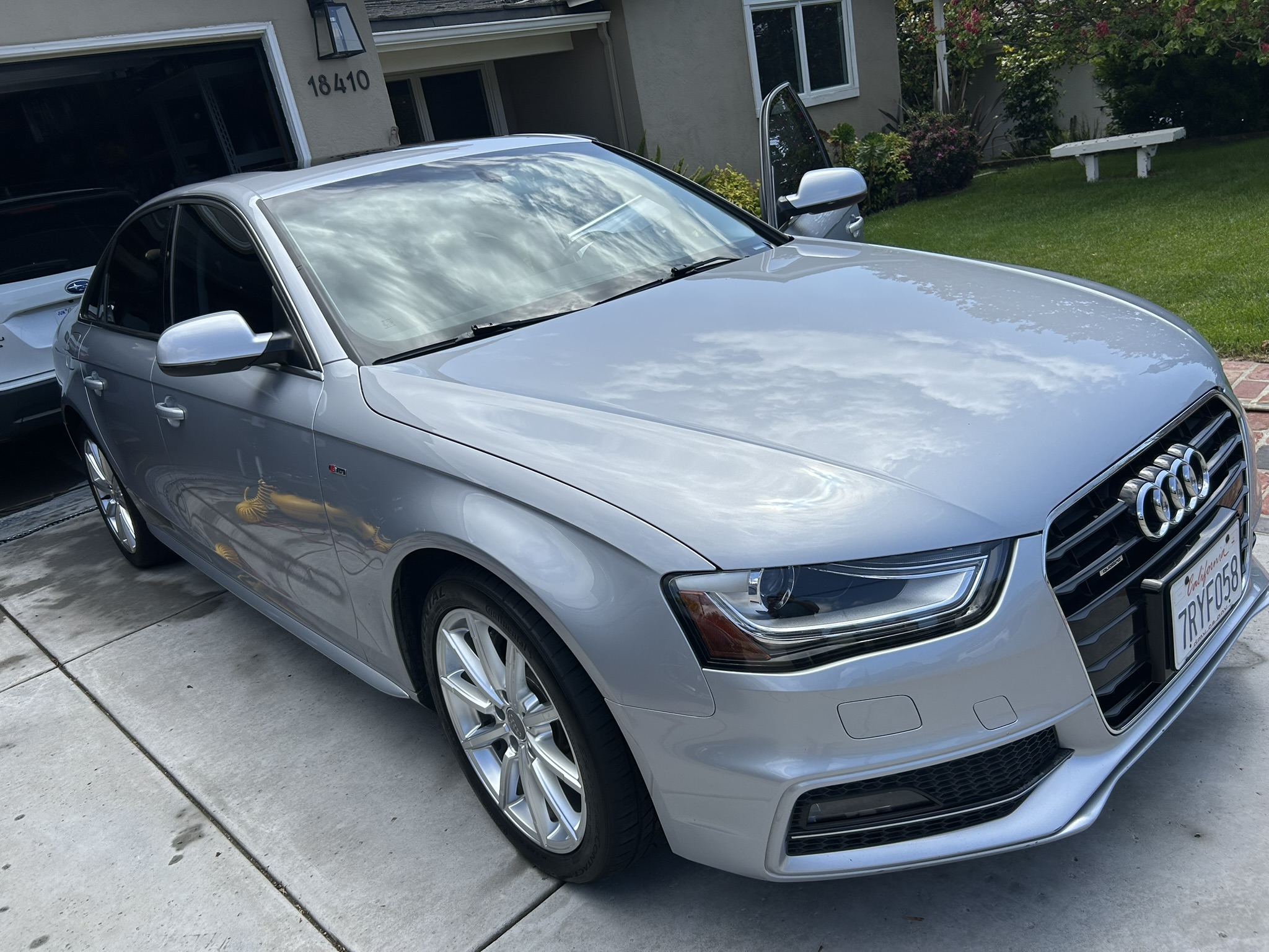 Hero image of a freshly detailed car. The paint reflects the clouds